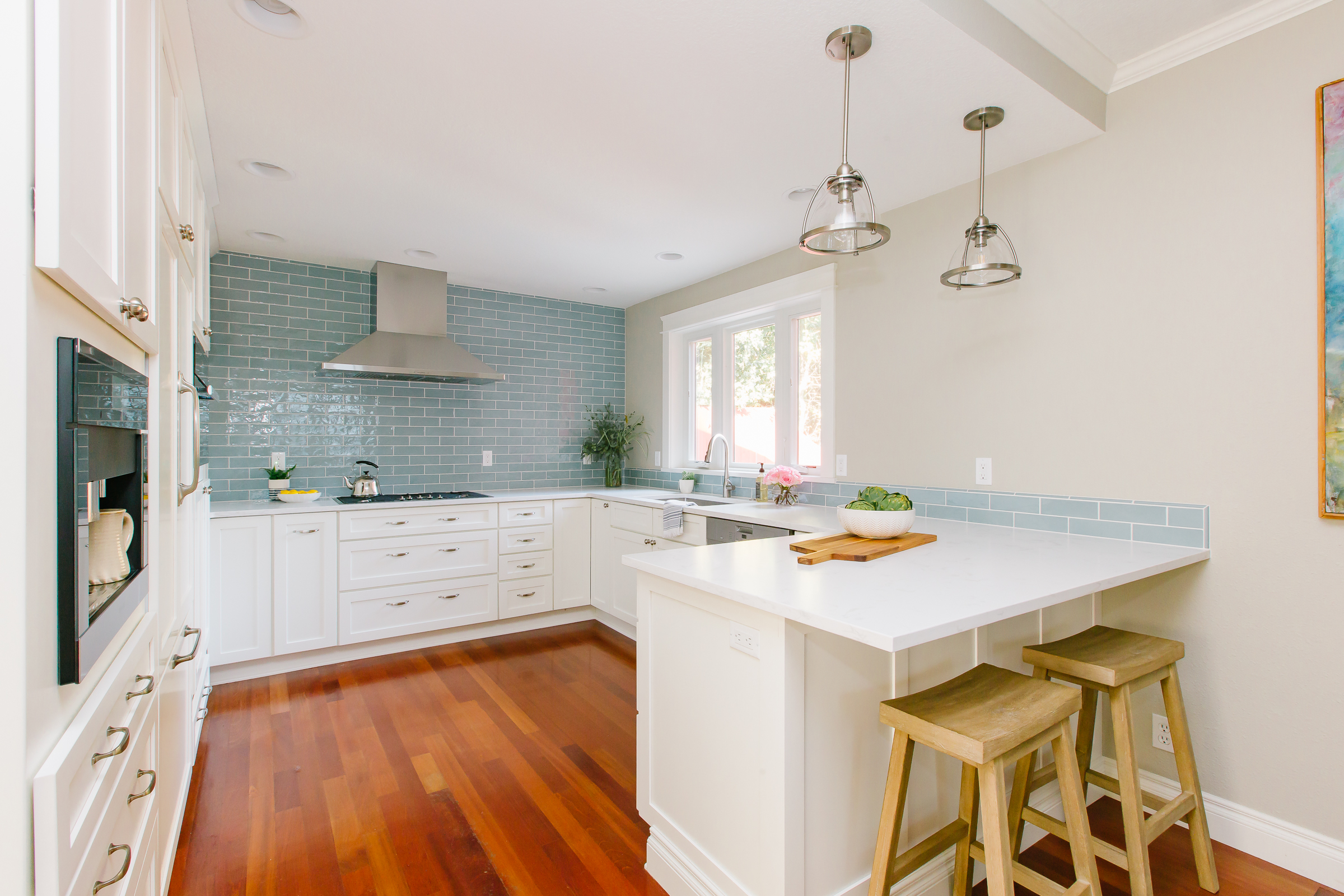 Historical home kitchen with light blue subway tile and white cabinets