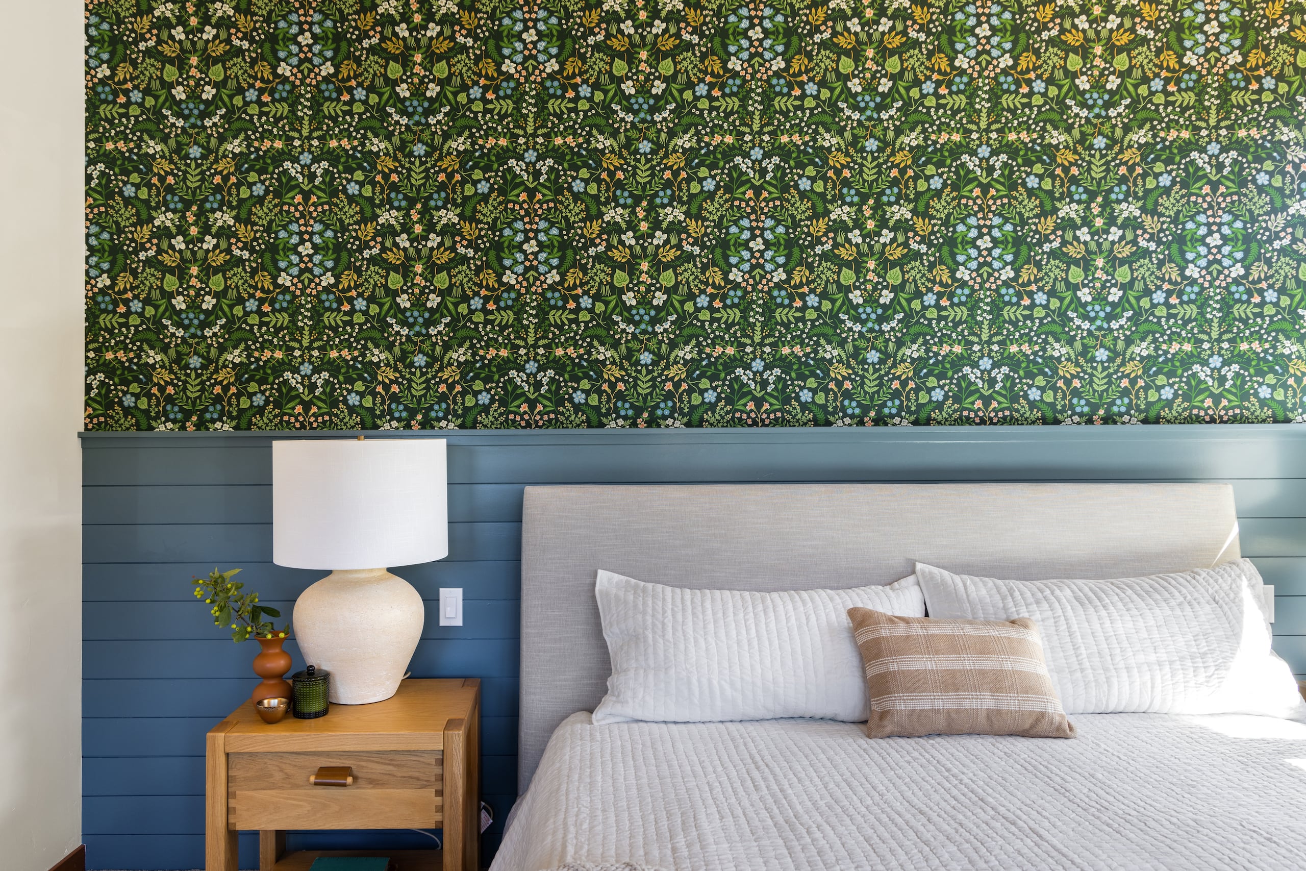 a bedroom with a colorful wallpaper and blue painted walls